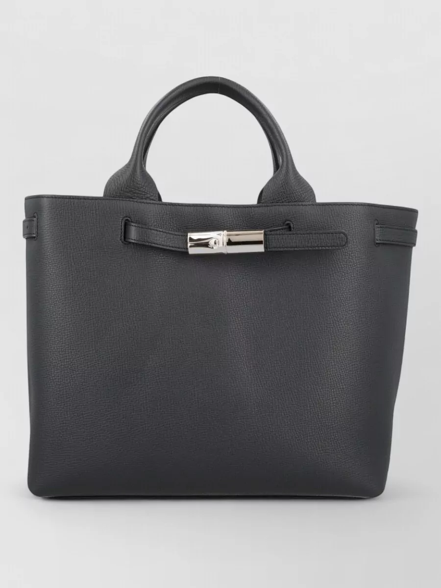 Longchamp Calf leather tote bag — Longchamp’s structured charcoal tote aligns with the formality and minimalist tailoring, echoing the trouser tone for a cohesive grey-black palette that feels authoritative but not severe.