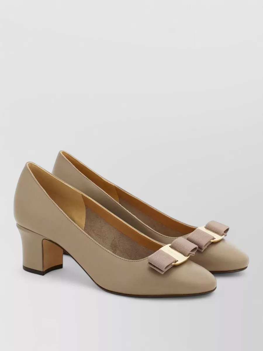 Ferragamo Leather pumps — The Ferragamo taupe mid-heel pump aligns with the dress’s formality and the bag’s beige-gold palette, giving a refined day-to-night finish that stays firmly in the quiet-luxury space.
