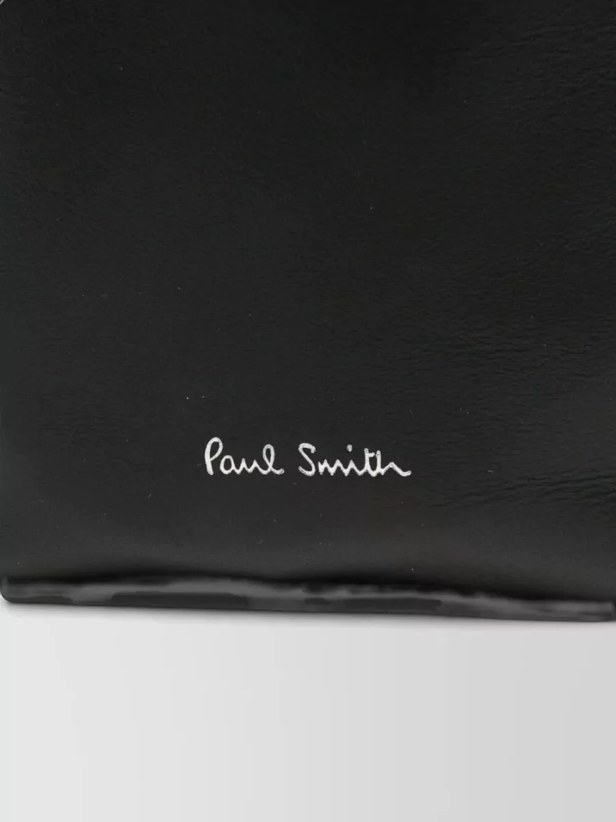 Paul Smith Leather crossbody bag — The compact black Paul Smith crossbody is sleek and understated, echoing the black logo detail on the knit and keeping the overall line clean and practical for city dressing.