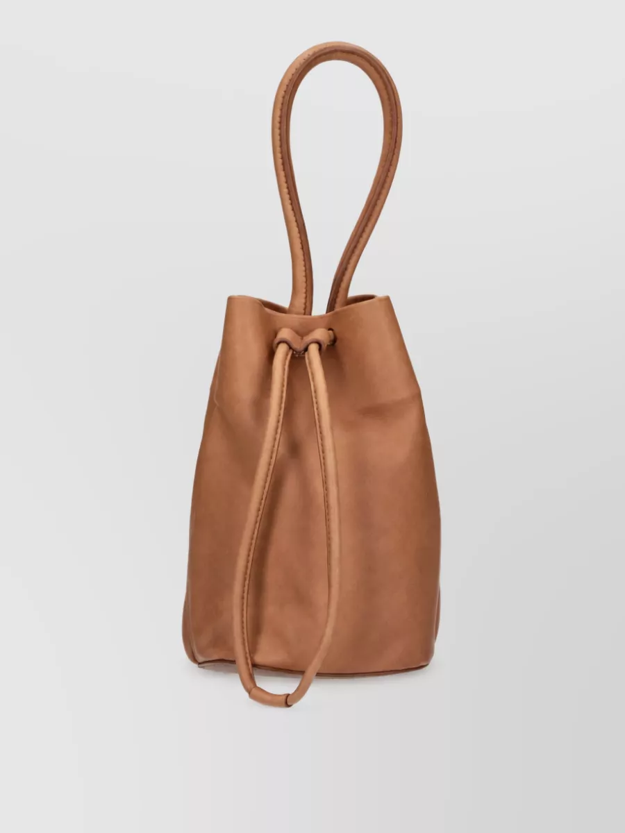 Uma Wang Leather tote bag — The tan bucket tote in B echoes the warm squares of the dress and adds soft structure at a similar price tier, keeping the palette earthy and cohesive without overwhelming the graphic check.