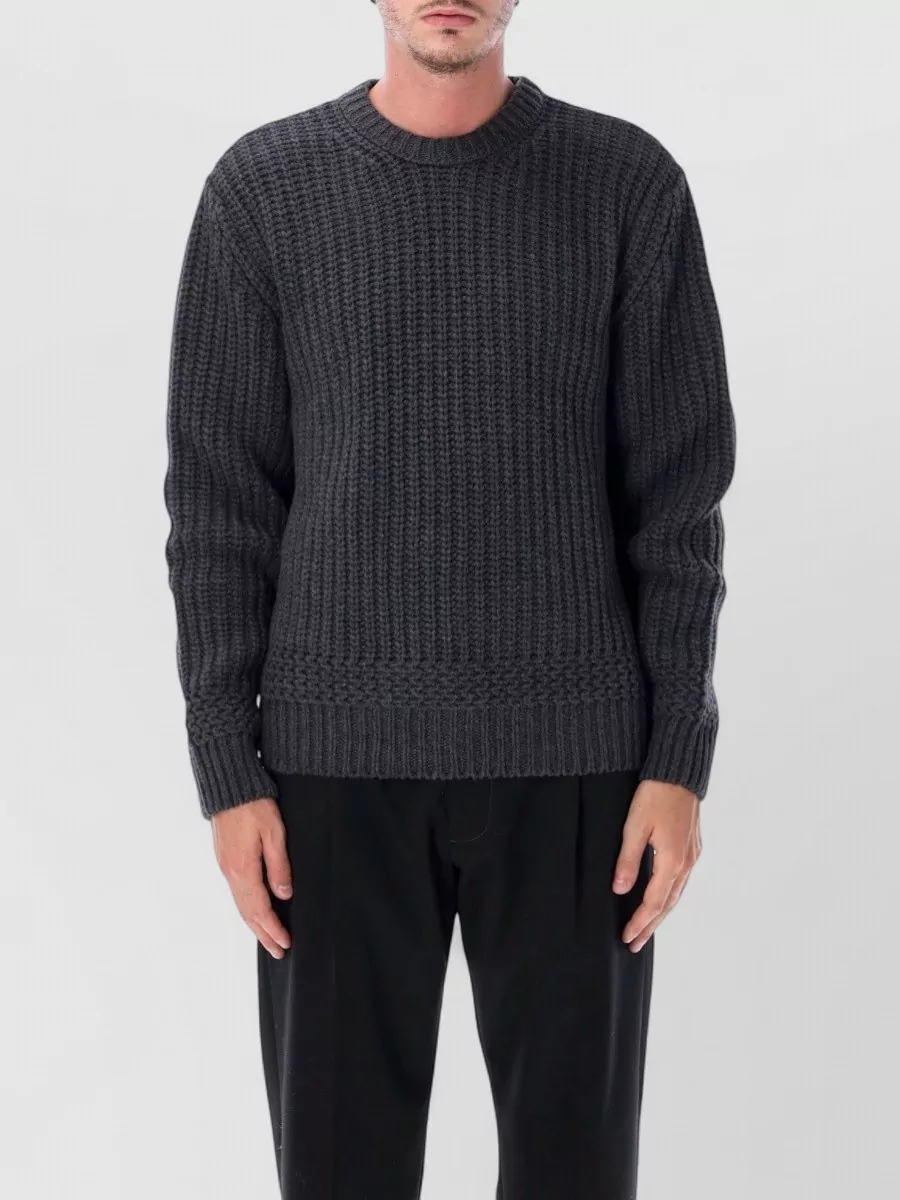 A.P.C. Recycled wool mixed knit crew neck jumper — The mossy melange crewneck balances the wide stonewash denim with a grounded FW texture and earthy tone that keeps the mood minimalist and quietly refined rather than graphic.