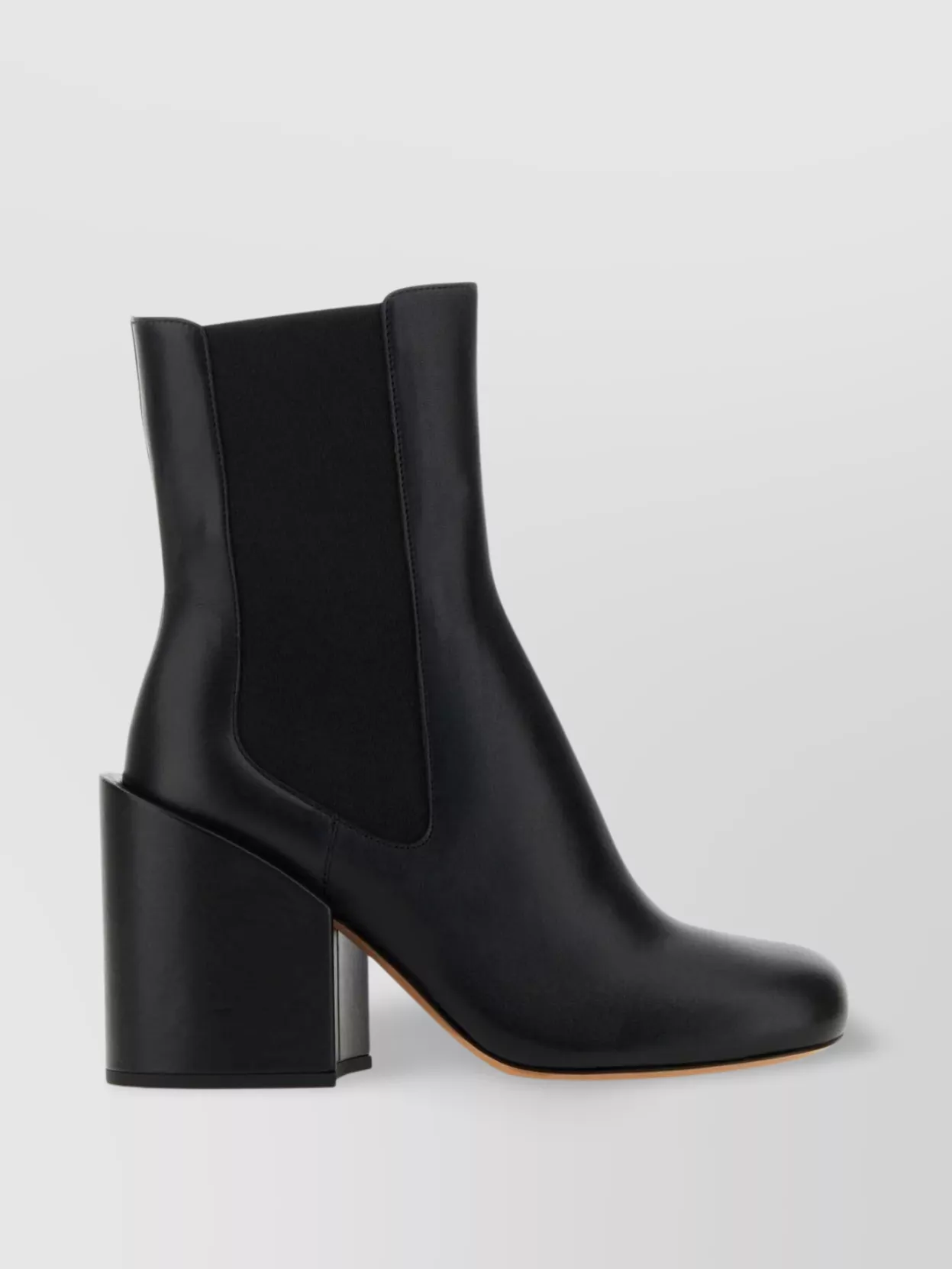 Sportmax Leather ankle boots — Sportmax’s sleek black ankle boot with a sculpted block heel continues the clean tailoring line, adds subtle height to the wide-leg trouser, and stays in the same understated, minimalist register.