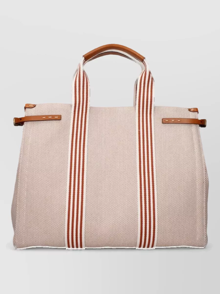 Valentino Garavani Fabric tote bag — The beige-and-cognac Valentino tote picks up the warm brown tipping on the polo, adding a refined contrast to the navy trouser and white sneaker while staying firmly in a luxury tier.