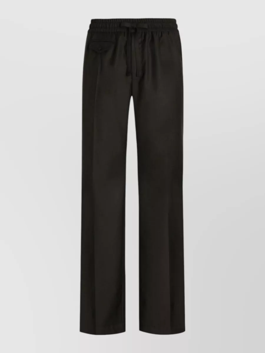 Dolce&Gabbana Wool jogging pants — The pleated straight-leg drawstring trouser keeps the all-black palette and streetwear ease of the sweatshirt but adds a sharper, quiet-luxury line than pure joggers.