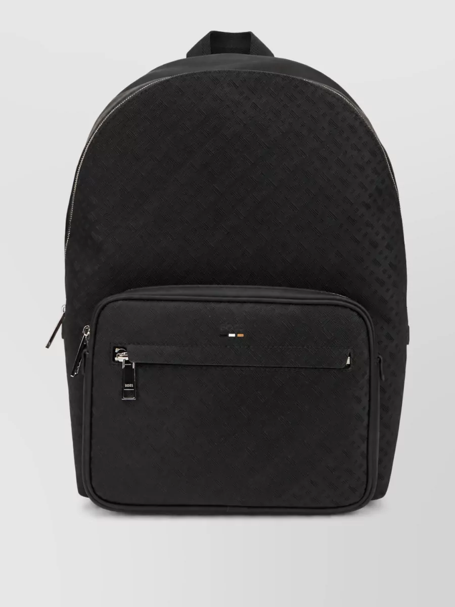 Boss Backpack — The slim black structured briefcase aligns with the formal, office-centric mood and mirrors the clean lines and subtle detailing of the tailoring.