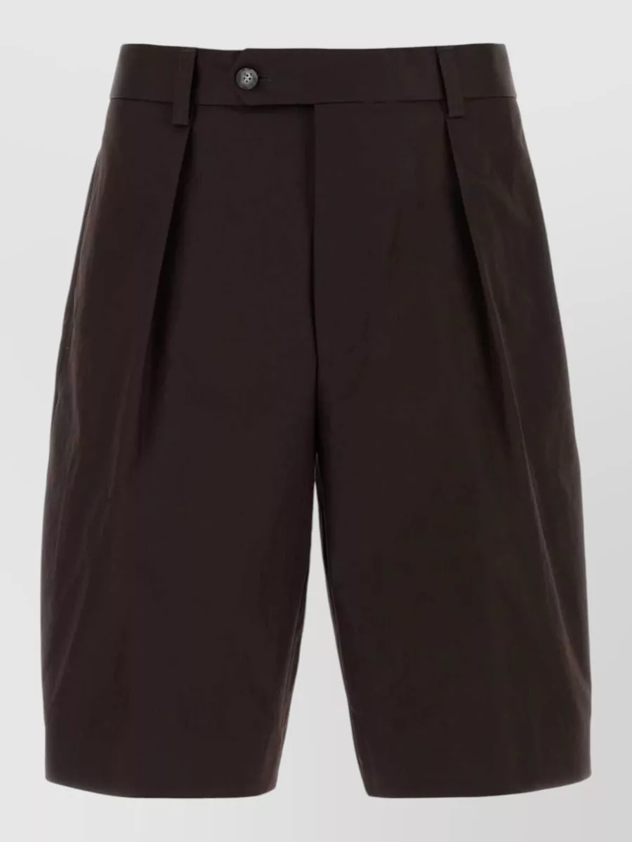 Boss Cotton pleated bermuda shorts — The off white pleated Boss shorts echo the tee’s quiet-sport cuffs and light gold-beige palette, keeping the outfit airy, minimalist and Spring-focused while adding a subtly tailored line.