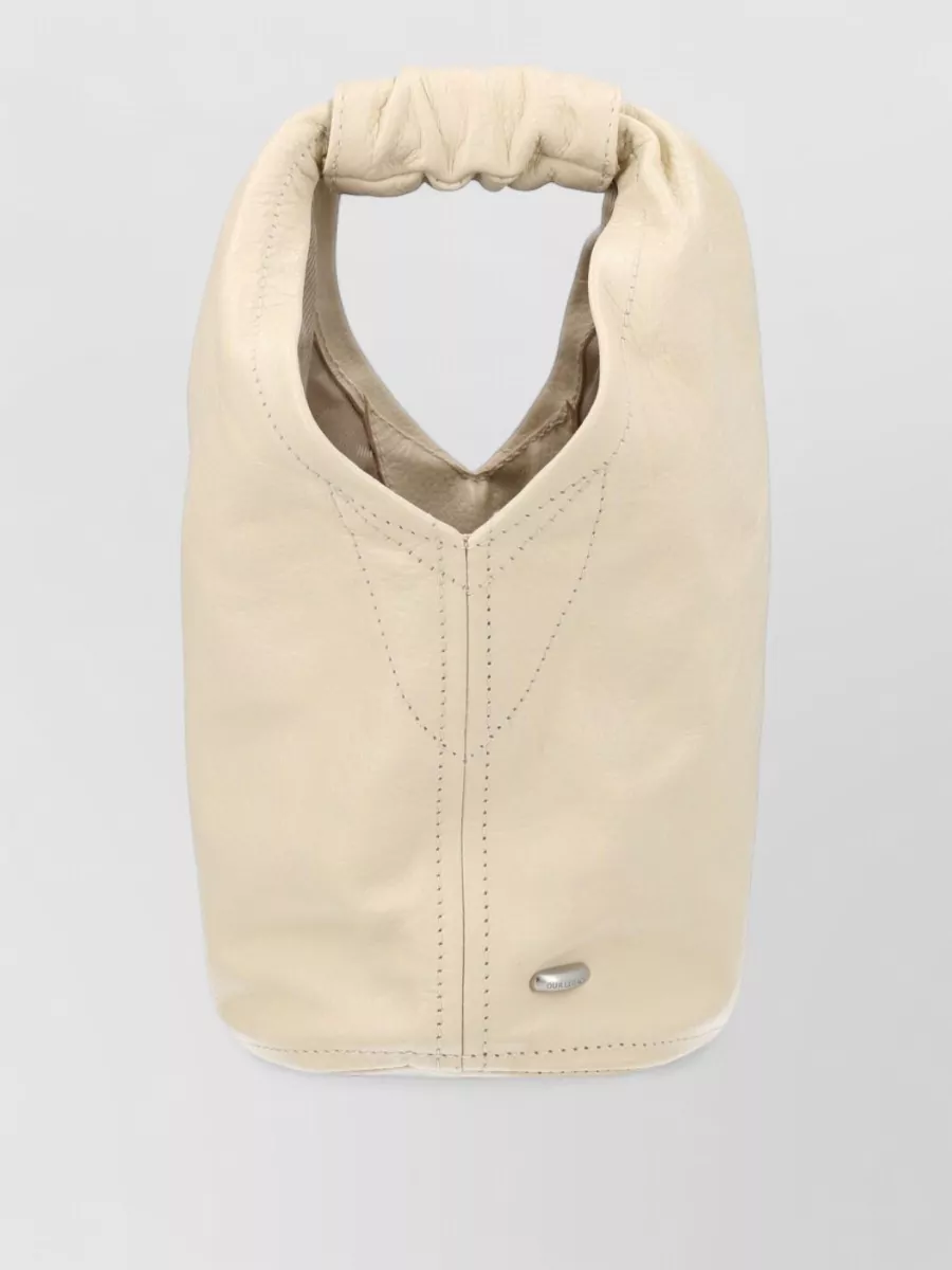 Our Legacy Leather tote bag — The A.P.C. indigo denim tote adds a slightly more grown-up, minimalist edge while staying casual, and its deep blue ties seamlessly into the navy short without competing with the soft yellow.