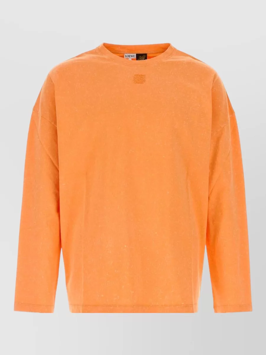 Loewe Paula's Ibiza Cotton t-shirt — The washed orange Loewe long-sleeve balances the bold navy‑tobacco print of the swim shorts with warm, sun‑drenched contrast while keeping the vibe relaxed and sport‑boho within the same Paula’s Ibiza universe.