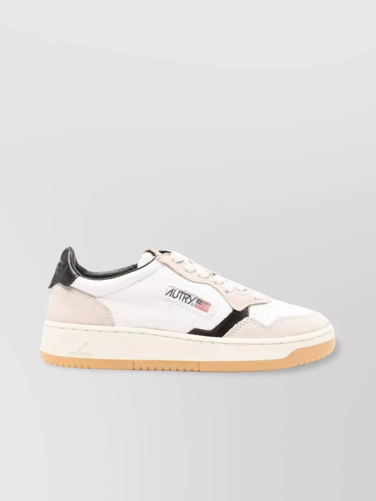 Autry Leather low-top sneakers — The black and white Autry court sneakers tie back to the knit’s black ground and the skirt’s navy-and-white palette, keeping the outfit sharp, sporty and coherent in tone.