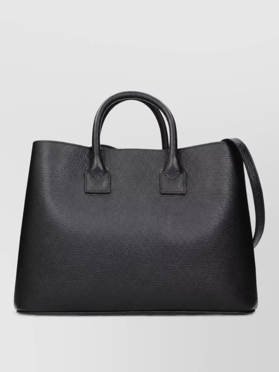 Burberry banwell tote leather tote bag — The structured black Burberry tote aligns with the minimalist, high-tier tailoring story and balances the light trouser, giving a polished but understated finish suitable for dinners or events.