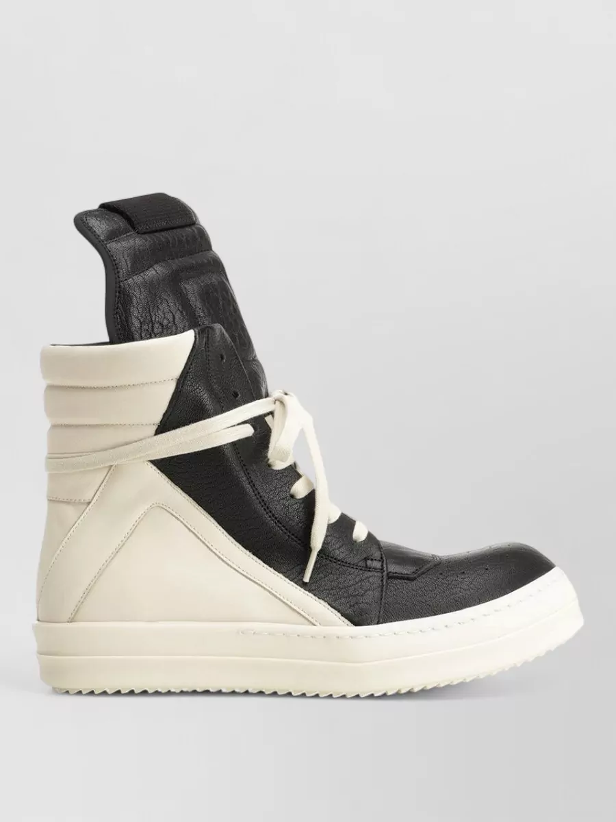 Rick Owens Leather high-top sneakers — The classic black and off-white high-top with exaggerated tongue balances the wide leg, echoes the tee’s contrast graphic, and anchors the outfit in pure Rick language.