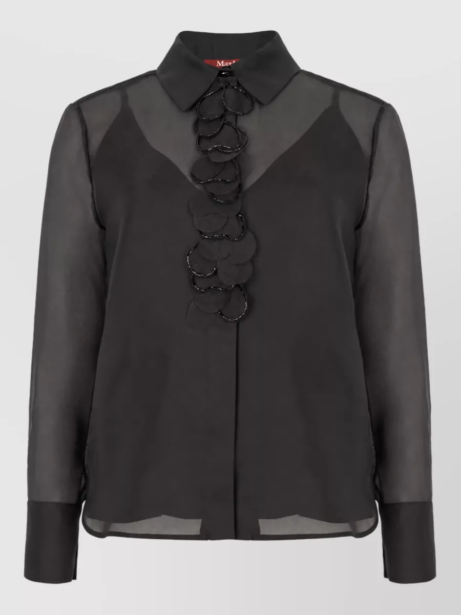 S Max Mara Silk chiffon long-sleeve shirt — The sheer black S Max Mara blouse adds sensual polish and tonal depth against the camel trousers while keeping the tailored, quiet luxury formality of a city dinner or client evening.