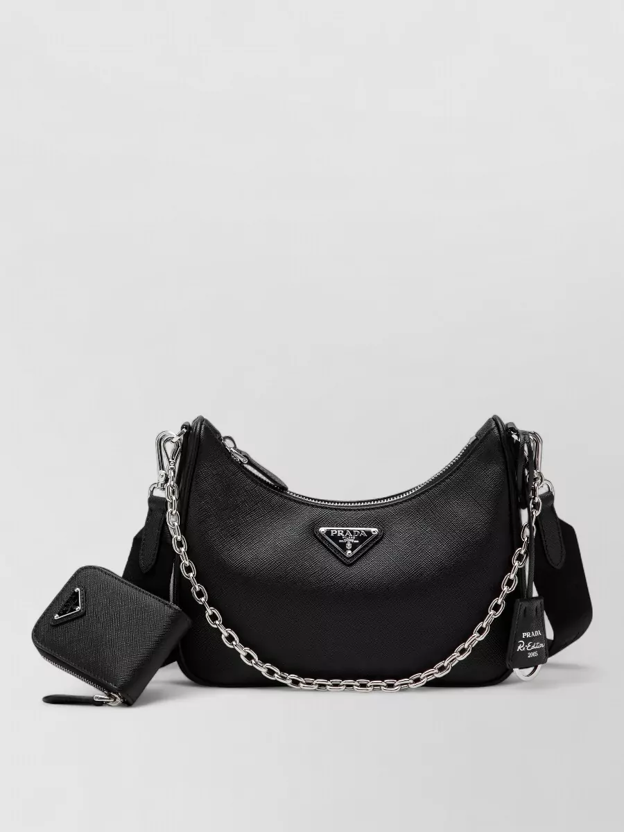 Prada Na shoulder bag — The black crescent bag with silver hardware adds a compact, urban finish that suits the relaxed jogger-and-sweatshirt pairing while keeping everything firmly in the Prada streetwear universe.