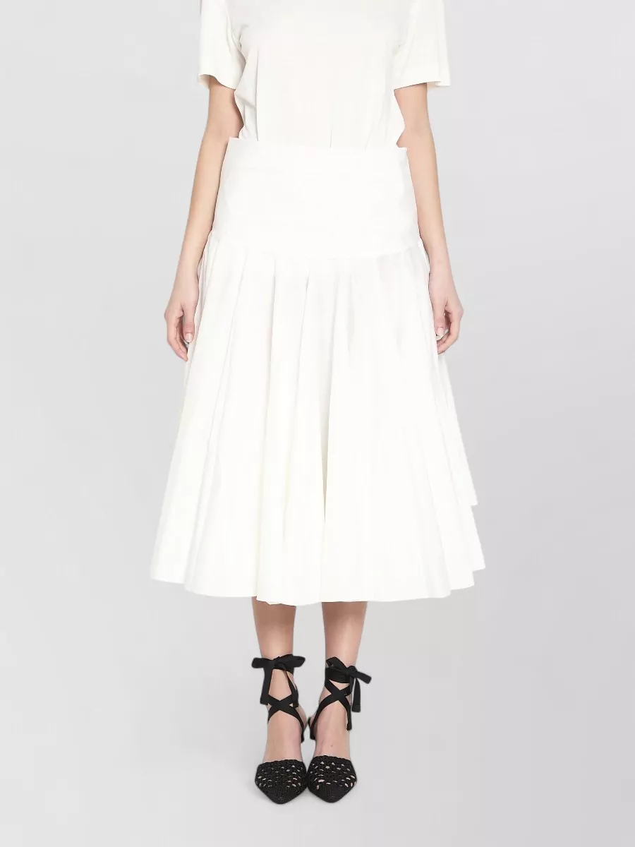 Jacquemus High-rise draped midi skirt — The high-waisted wide-leg trouser in soft white keeps the look crisply monochrome and quiet-luxury while balancing the blouse’s dramatic bell sleeves with a long, clean, tailored line.
