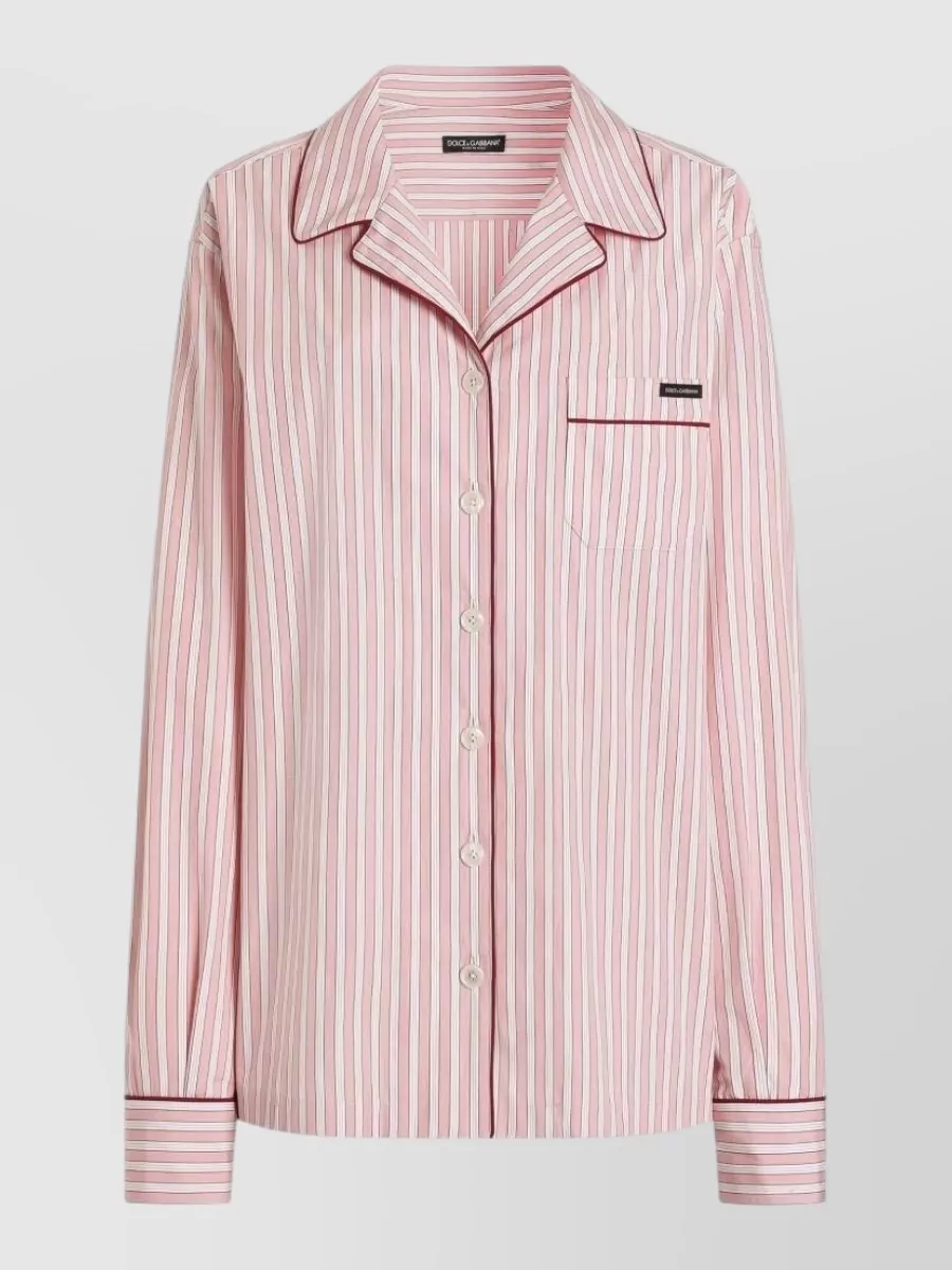 Dolce&Gabbana Striped pajama shirt — The Dolce&Gabbana striped pajama shirt in soft pink and burgundy mirrors the shorts’ palette and preppy loungewear mood, creating a coordinated yet relaxed high-summer set.
