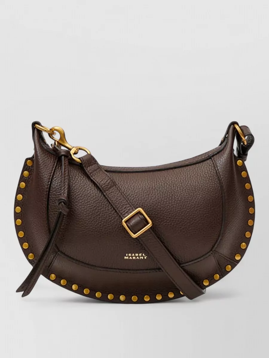 Isabel Marant oskan moon leather shoulder bag — The dark chocolate saddle bag G harmonizes with the jacket’s antique gold embroidery and the boho-western boots, adding structured quiet luxury without introducing a new color story.