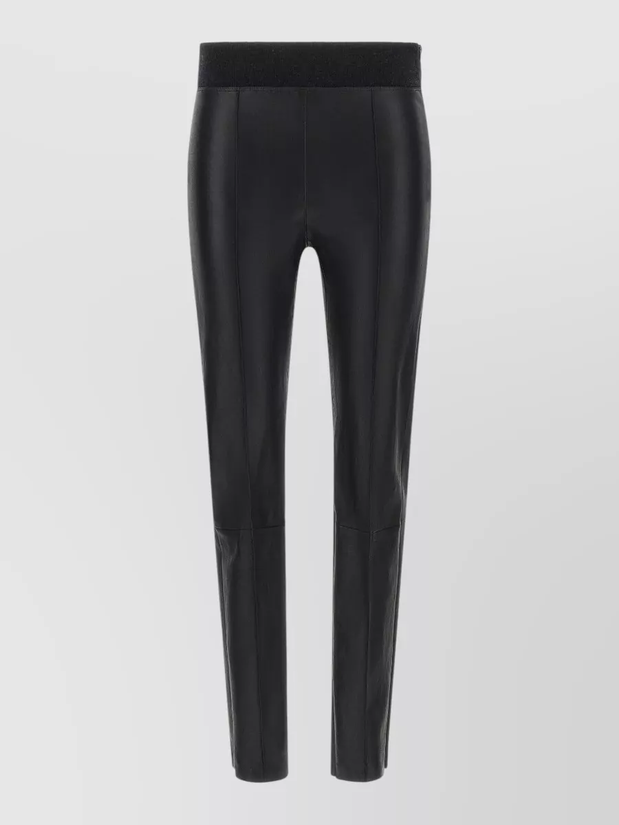 Brunello Cucinelli Leather paneled skinny leggings — The high-rise slim black trouser pairs with the sequined knit to hit the same refined evening-casual formality, keeping the line sleek and elongating against the relaxed crew.