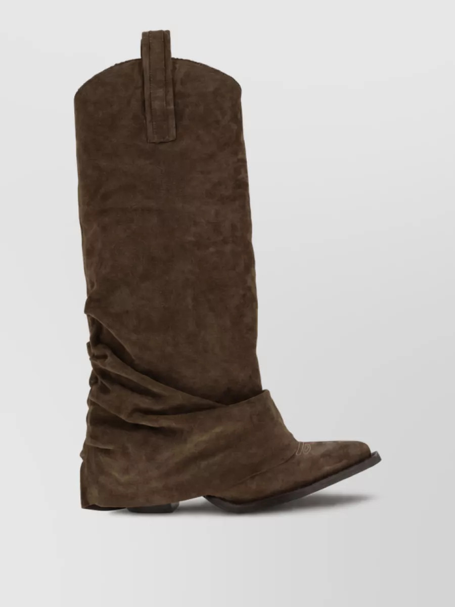 R13 Leather ankle boots — The slouchy dark chocolate R13 western boots extend the brown story from hip to toe and mirror the flare of the jean, keeping the vibe streetwise, boho, and high-end consistent.