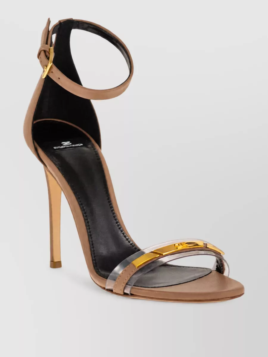 Elisabetta Franchi Leather sandals — The nude, barely-there stiletto sandal with subtle gold detailing reinforces the Y2K edge, lengthens the leg against the ivory trouser and matches the outfit’s dressy, night-out formality.