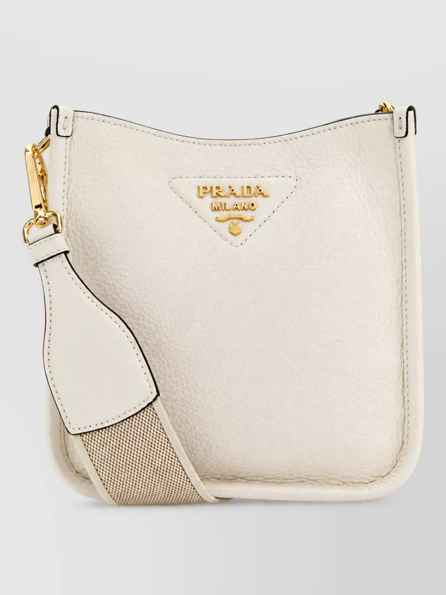 Prada Na calf leather cross-body bag — The warm ivory structured crossbody keeps the outfit light and tonal, echoing the clean lines of the tank and skirt without visually weighing down the column silhouette.