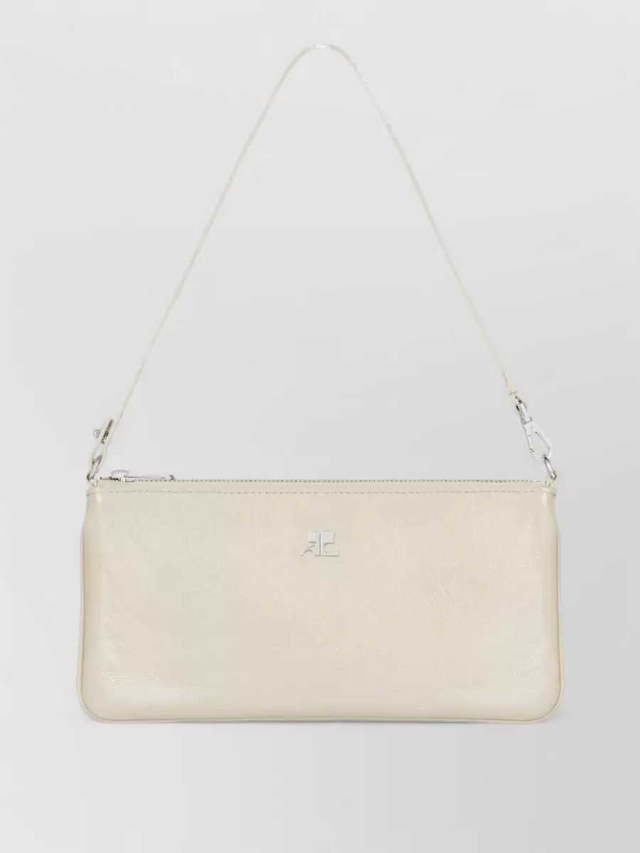 Courrèges cloud leather clutch bag — The Courrèges buttercream clutch keeps to the same refined nude spectrum as the dress and shoes while its sleek, 90s line adds a subtle modern edge without overpowering the softness.