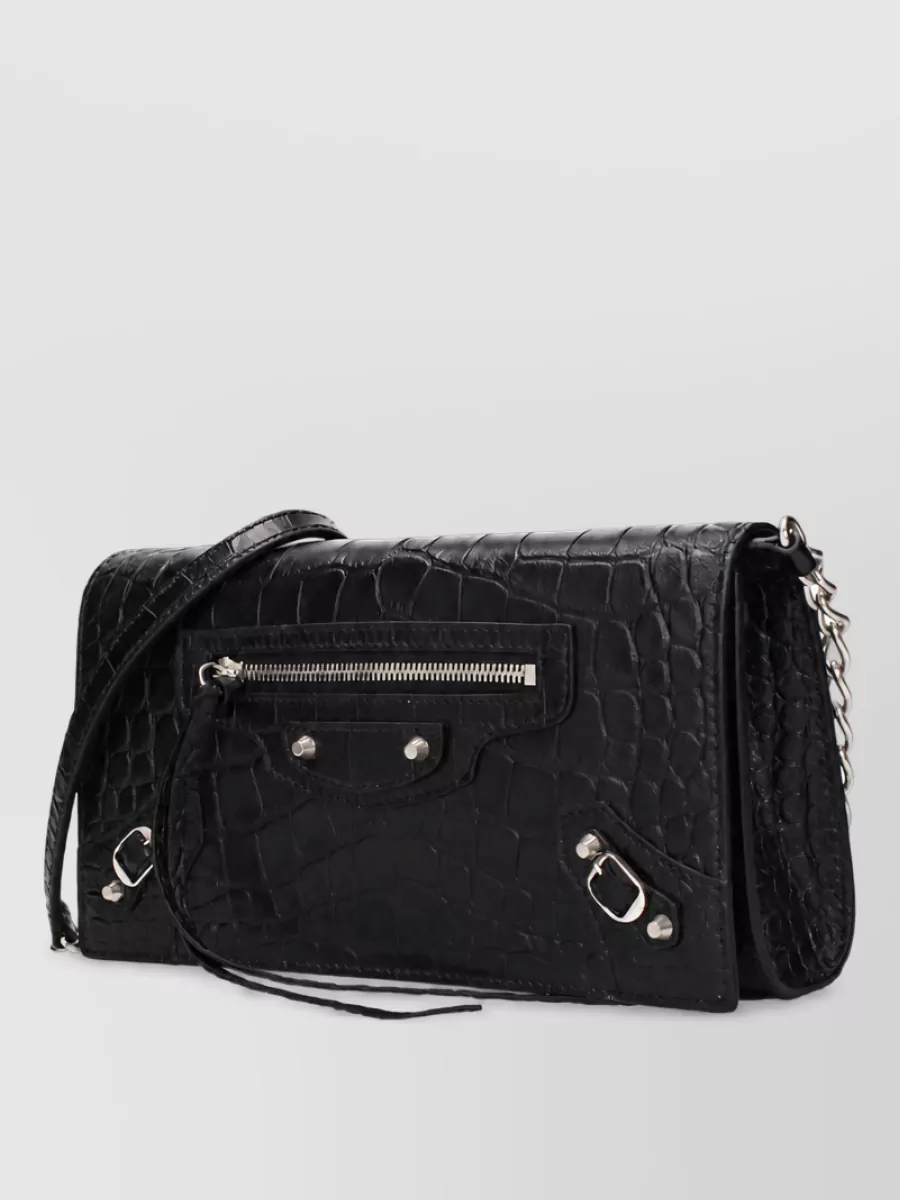 Balenciaga Na leather shoulder bag — The Attico’s sharp black baguette echoes the cut-out top’s graphic minimalism and sits perfectly at the underarm, in scale with the mini and high boots for a tight, night-out silhouette.
