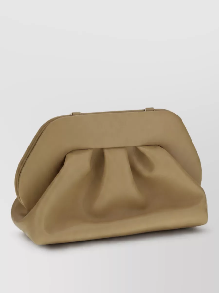 Themoiré Clutch bag — The camel Themoiré padded clutch sits in the same neutral family as the shoes, adds sculpted volume against the fluid dress, and keeps the palette warm and refined.