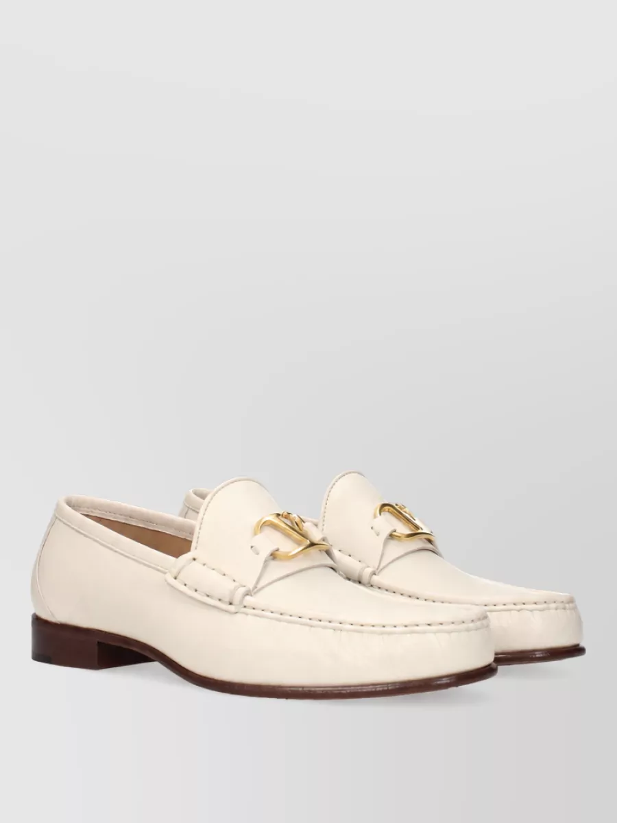 Valentino Garavani Leather loafers — Valentino Garavani’s cream loafers echo the light neutrals of the knit and trouser, their low-heeled, polished profile keeping the outfit smart yet relaxed in a consistent quiet-luxury register.