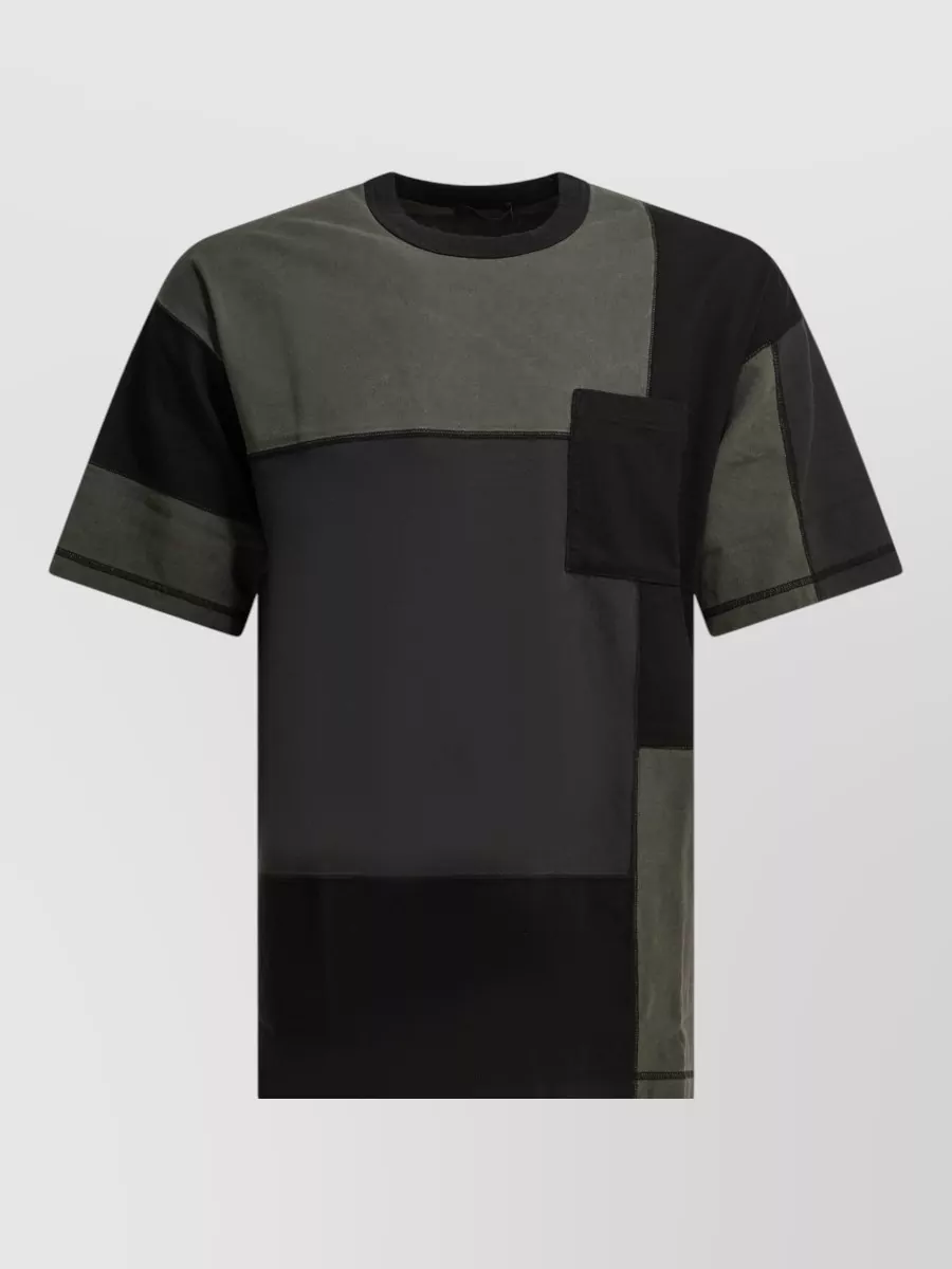 Comme Des Garçons Homme Patchwork crewneck t-shirt — The Comme Des Garçons Homme patchwork tee keeps the palette dark and tonal with the black cargo shorts, adding subtle structure and streetwear edge without breaking the utilitarian mood.