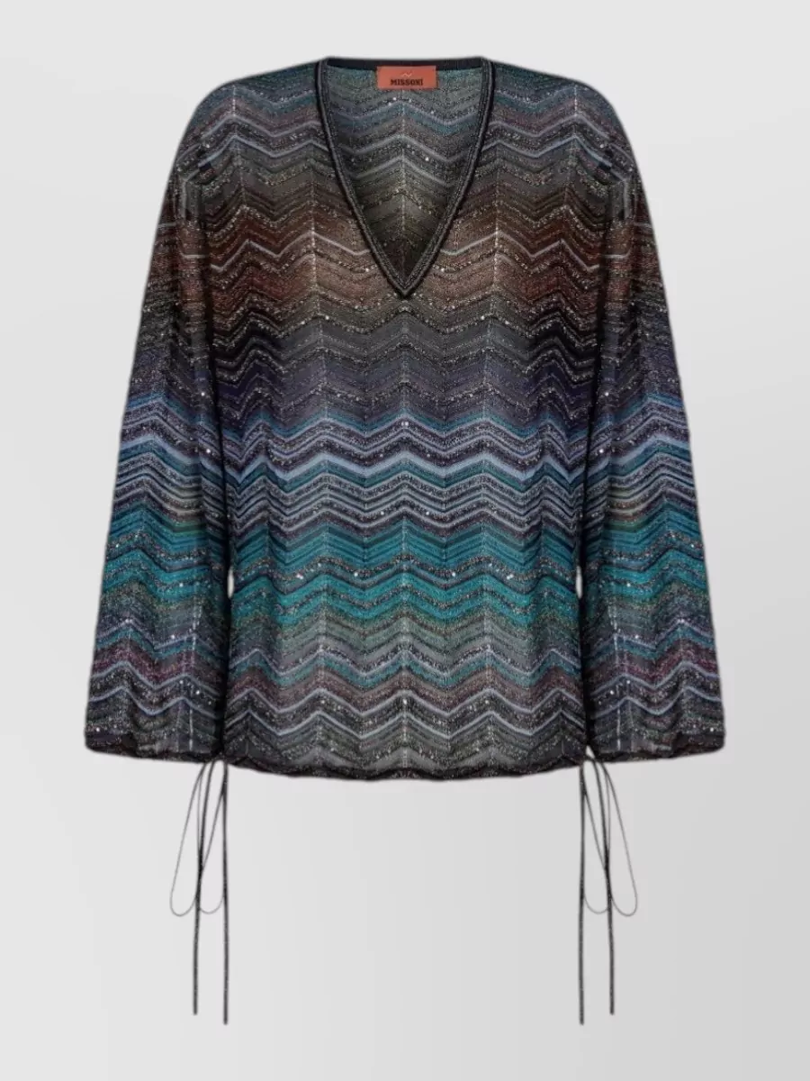 Missoni Blouse — The moody ombré V-neck in inky blues and earthy tones closely echoes the trouser palette, keeping the all-Missoni knit story cohesive while its sheer drape balances the wide-leg with a fluid, slightly sultry top line.
