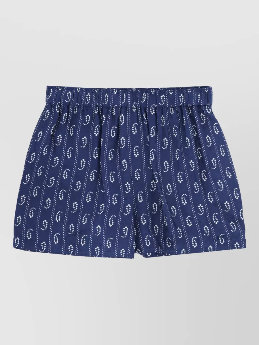 Tory Burch Silk camp pyjama shorts — The matching navy printed boxer short keeps the pajama inspiration intentional and polished, creating a coordinated preppy lounge set in the same palette and brand tier.