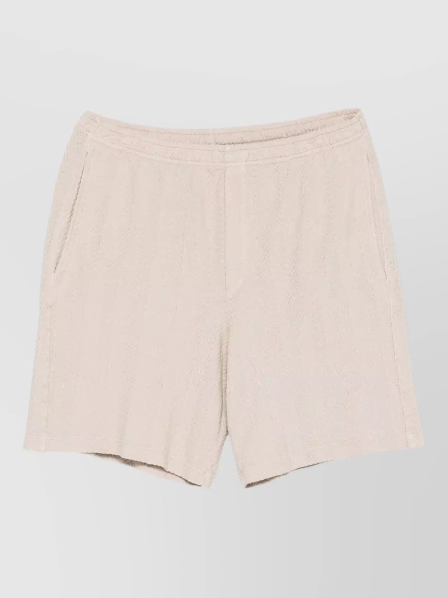 Missoni Tailored shorts — The Brunello Cucinelli ivory knit short in G quietly grounds the vivid Alanui cardigan with a light neutral, keeps the boho-quiet-luxury mood, and suits relaxed warm-weather proportions.