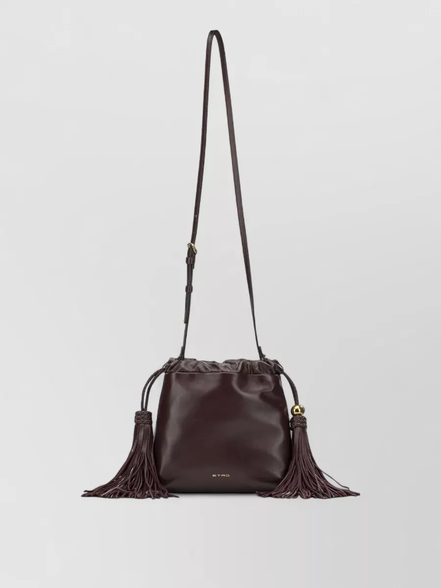 Etro Small lamb leather shoulder bag — The deep wine drawstring pouch is the right evening scale and mood, picking up the dress’s burgundy notes and boho attitude without adding more print to an already story-rich piece.
