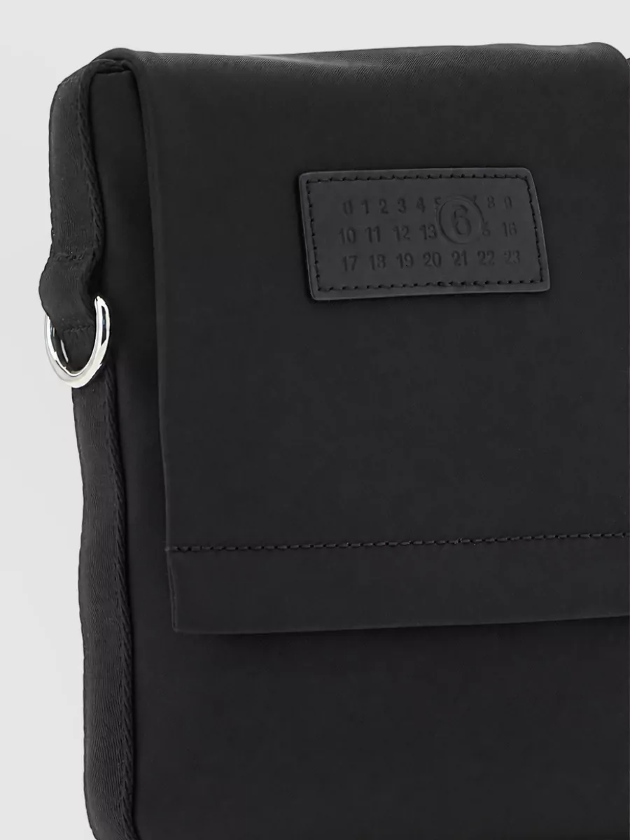 Mm6 Maison Margiela Technical crossbody bag — The black pleated Homme Plissé belt bag stays in the same monochrome, minimalist language while adding a quietly directional texture that suits a luxury multi-brand streetwear mix.