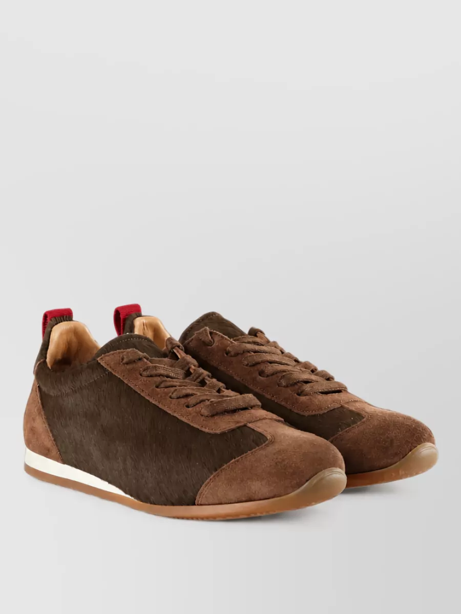 Uma Wang Calf hair low-top sneakers — Uma Wang’s brown-toned sneakers ground the culotte’s cognac and the Miu Miu cap’s dark brown, keeping the outfit street-led yet quietly refined.