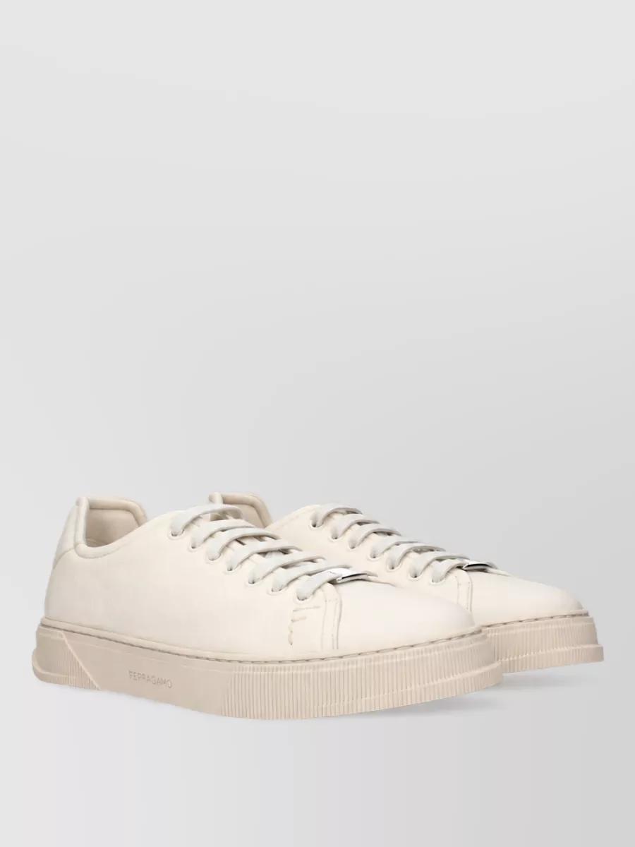 Ferragamo Leather sneakers — The Dolce&Gabbana taupe runner stays within the same neutral family as the knit and trousers, and its streamlined profile keeps the outfit polished yet casually grounded.