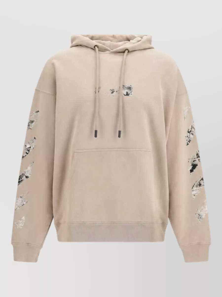 Off-White Cotton printed hoodie — The warm beige Off-White hoodie syncs with the sneakers’ off-white and black palette while adding branded streetwear energy and a relaxed volume that sits well over tapered pants.