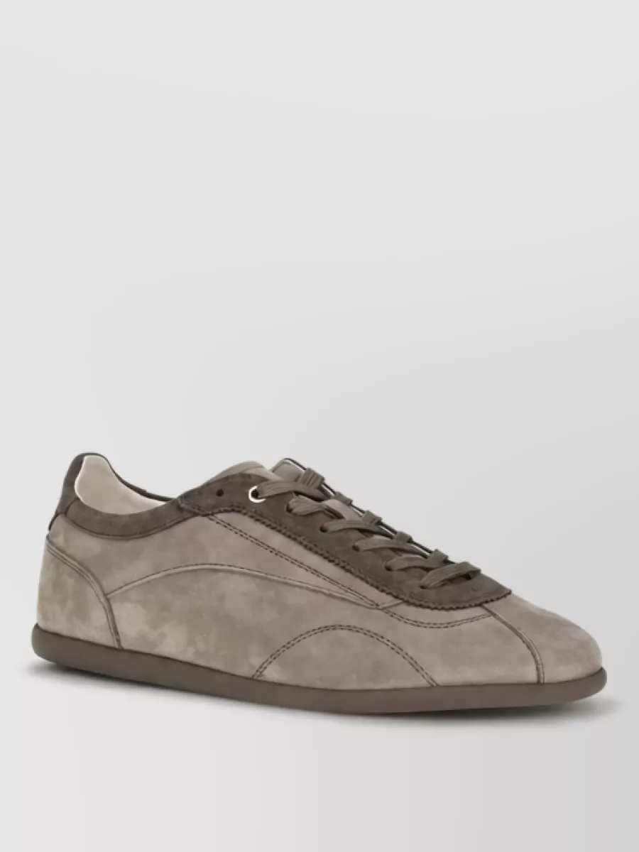 Brunello Cucinelli Calf leather lace-up sneakers — The taupe suede low-profile sneaker gives a quiet, cashmere-soft counterpart to the denim while keeping the outfit polished enough for smart casual days.