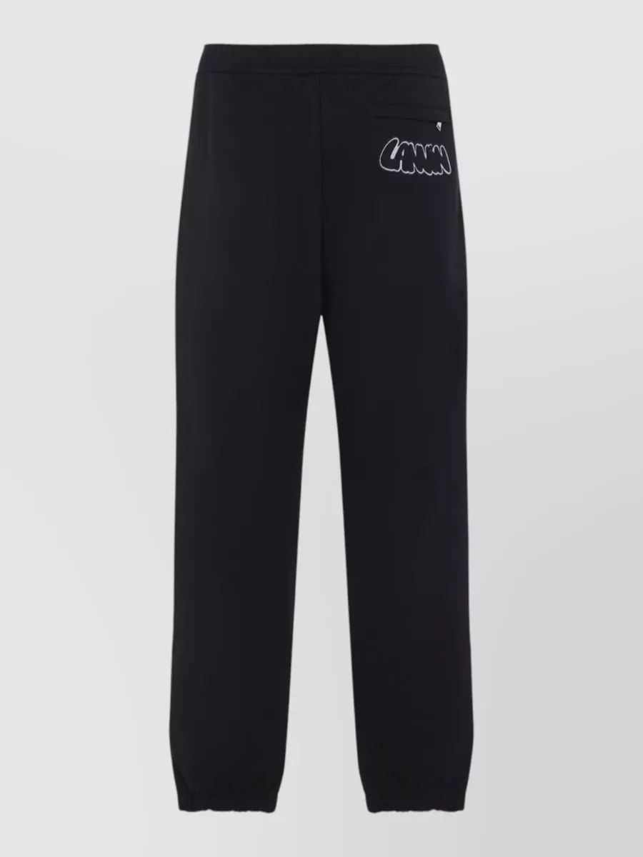 Lanvin Cotton logo-embroidered track pants — The black Lanvin jogger mirrors the sweatshirt’s minimalist sport mood and brand, giving a clean tapered line that keeps the palette tight and the formality casually polished.