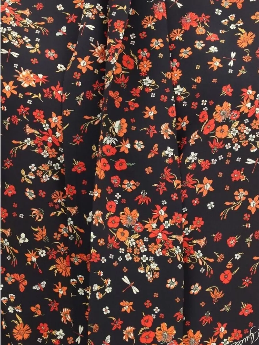 Gucci Silk shirt — The black-based Gucci floral blouse E mirrors the skirt’s romantic rose story while keeping a cohesive dark ground and fluid FW cocktail polish without overpowering the mini.