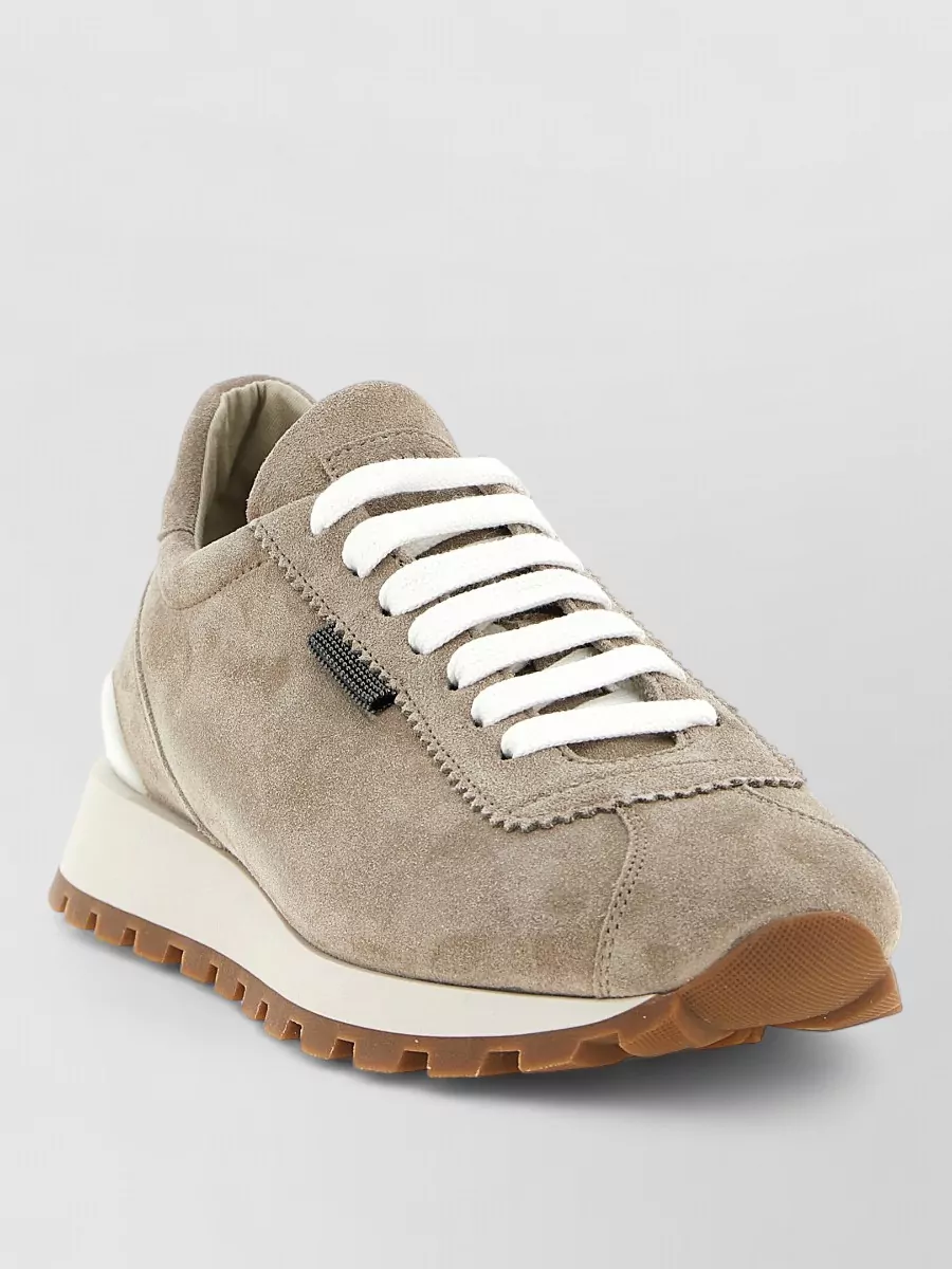 Brunello Cucinelli Suede lace-up sneakers — The taupe suede runners echo the sweater’s tone and sparkle with a quietly sporty profile, keeping the outfit polished yet relaxed and harmonizing with the dark brown trouser.
