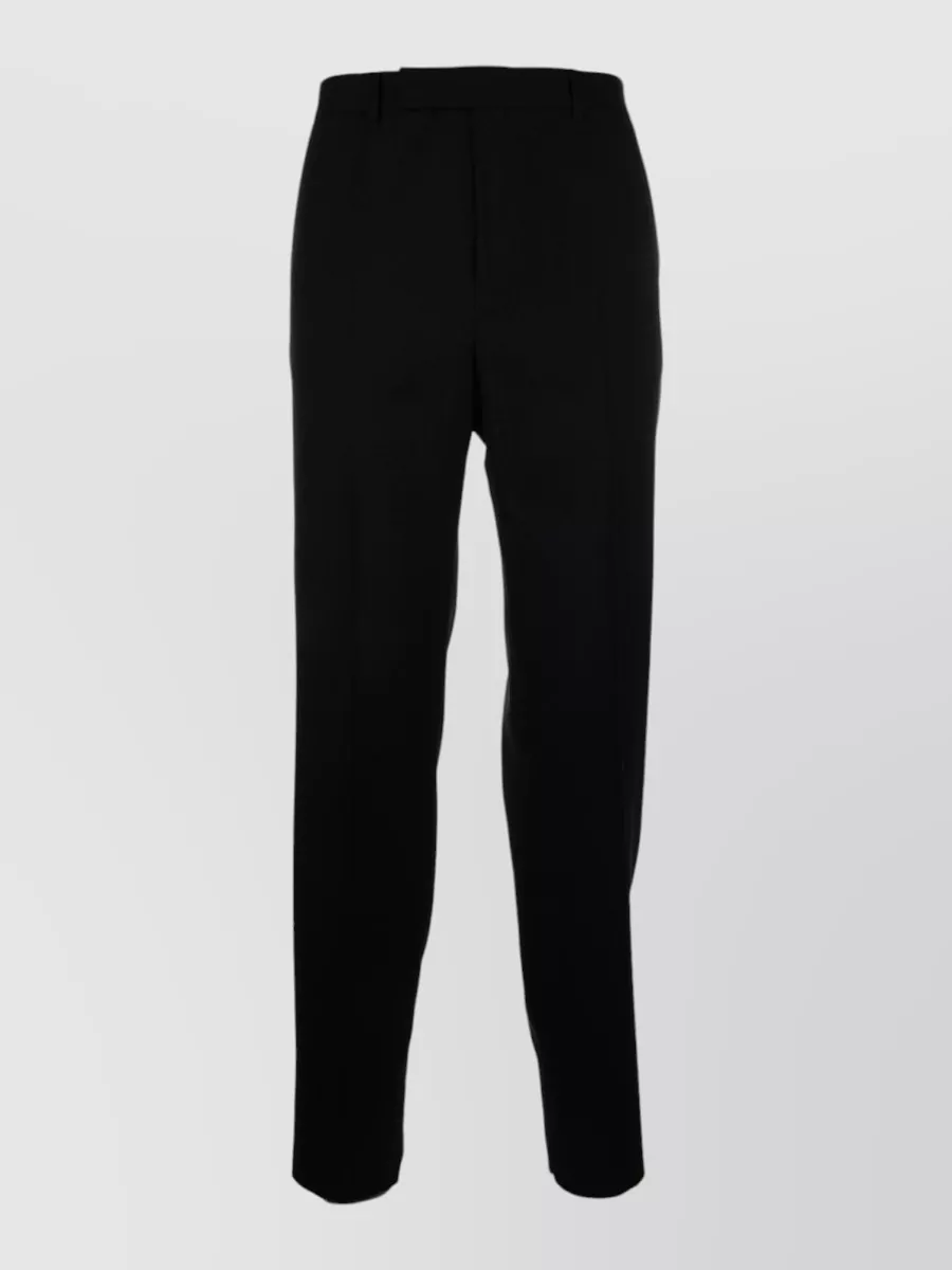Celine Wool straight-leg trousers — The clean black Celine trouser keeps the palette graphic, matches the brand and formality of the rugby polo, and delivers a sharp, regular line that reinforces the quiet luxury mood.