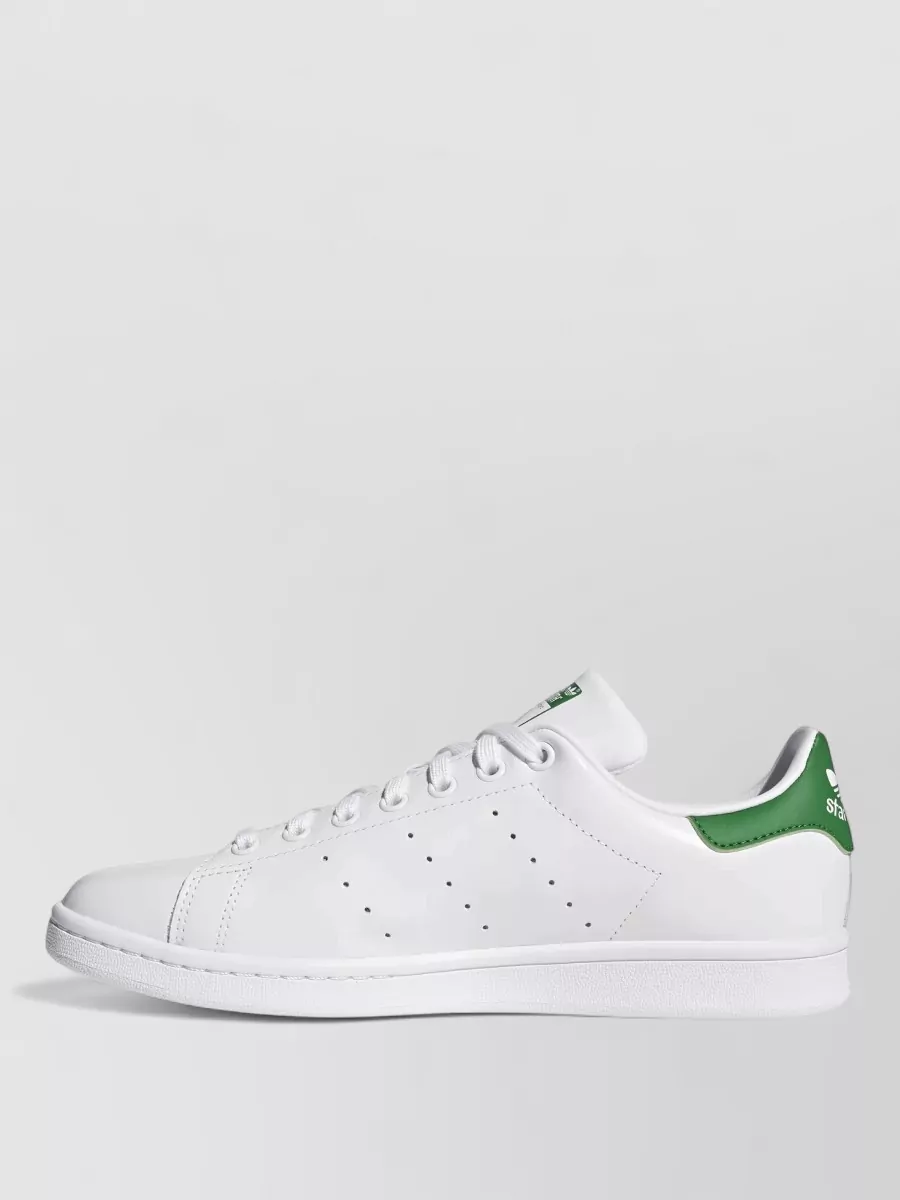 Adidas Leather low-top sneakers — The white Adidas court sneaker with green heel tab mirrors the Lacoste croc green and keeps the outfit polished but relaxed, ideal with a minimalist polo-and-shorts combo.