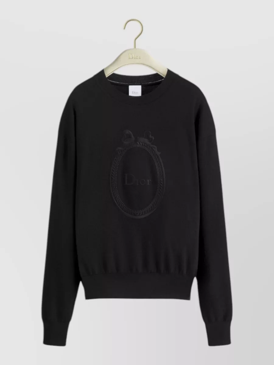 Christian Dior Jumper — The black Dior crewneck mirrors the coat’s minimalist quilting and haute-casual mood, creating a clean monochrome column that keeps the focus on texture rather than color.