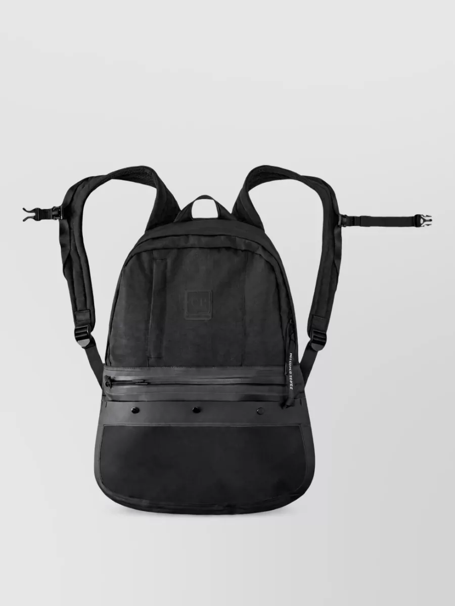 C.P. Company Quartz fabric backpack — The compact C.P. Company crossbody in charcoal black sits perfectly with the technical cargos and sneakers, adding practical storage and a subtle lens detail without overwhelming the clean lines.