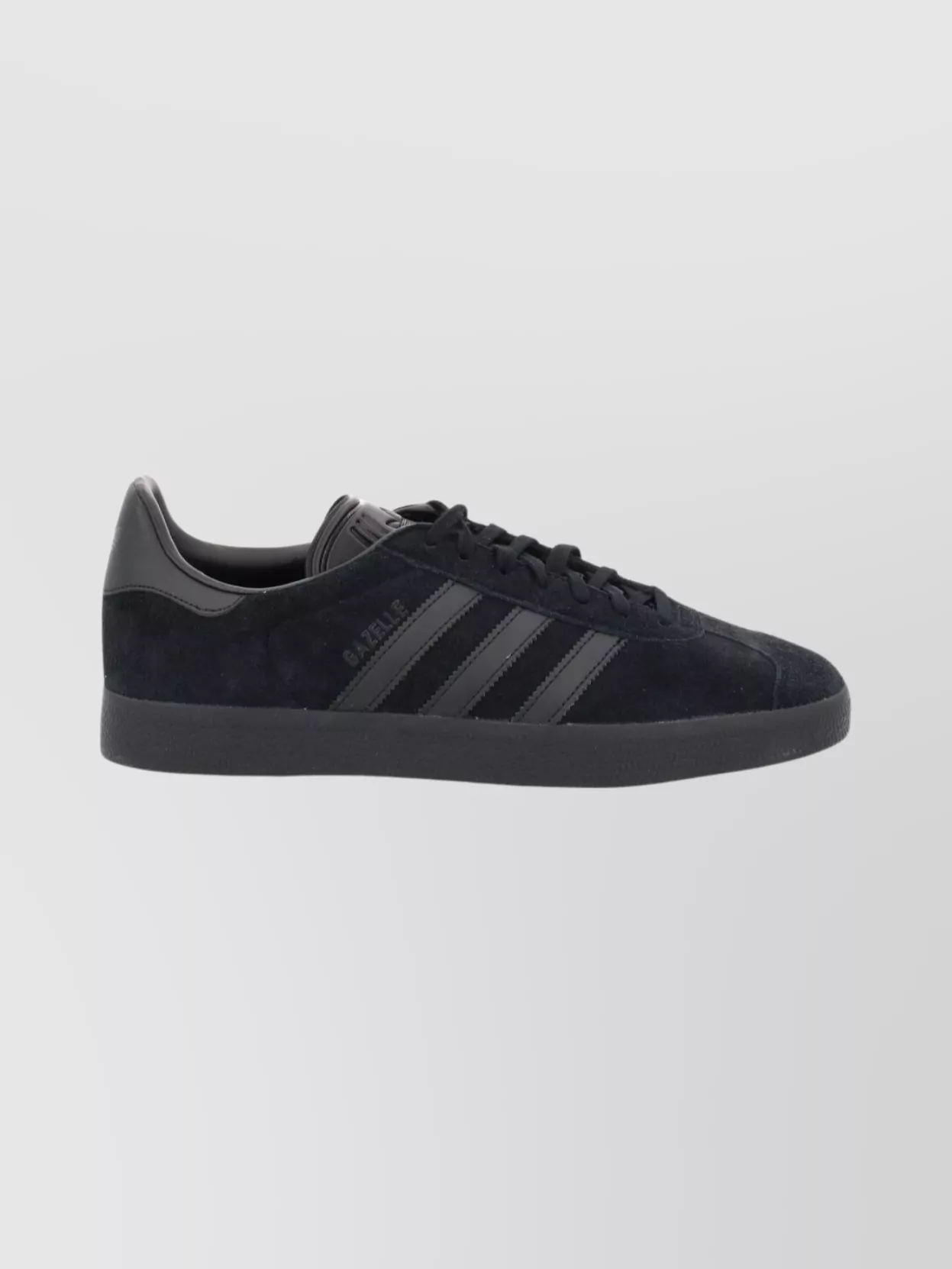 Adidas Originals Leather low-top sneakers — The all‑black Adidas Originals low-top keeps the outfit clean, graphic and sport-driven, aligning with the hoodie and dress tones without adding visual noise.