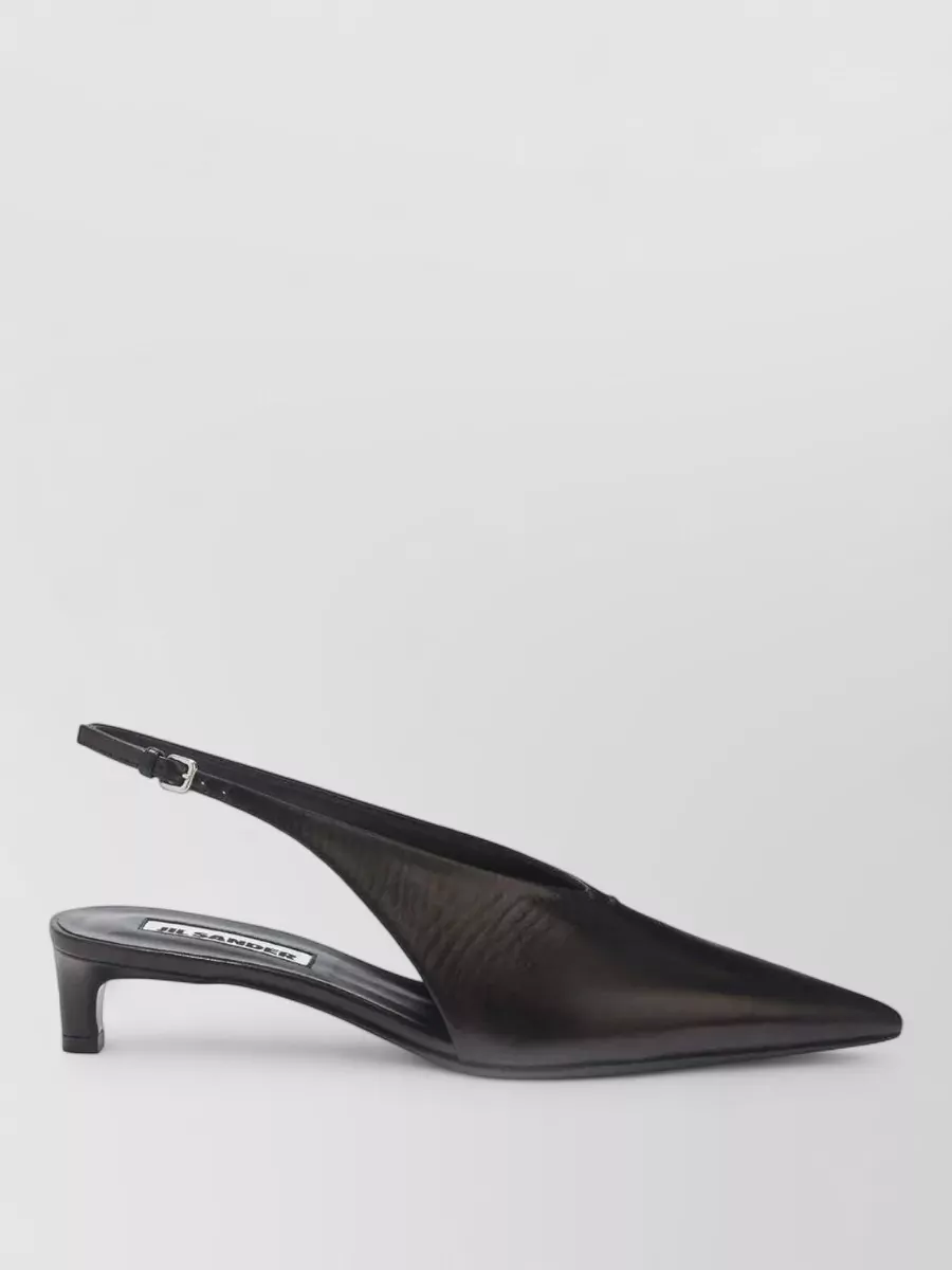 Jil Sander Leather slingback pumps — The Jil Sander black pointed kitten-heel slingbacks keep the line sharp and polished without overpowering the mini dress, matching the bag’s quiet, architectural feel and cocktail formality.