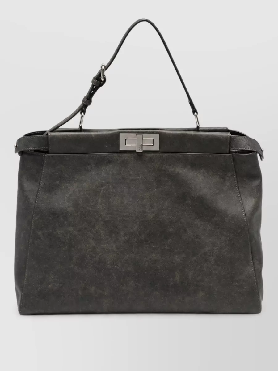 Fendi Leather clutch bag — The structured charcoal clutch with top handle reads like a soft briefcase, echoing the charcoal-black tailoring story and reinforcing the discreet, business-adjacent quiet luxury of the outfit.