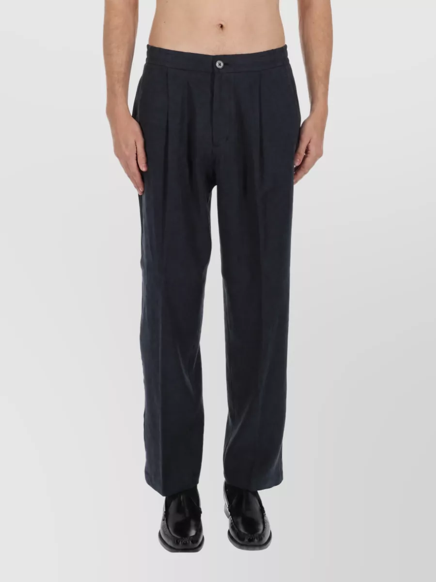 Herno Straight-leg trousers — The charcoal‑navy pleated trouser keeps the palette deep and minimal against the soft white tee, with a relaxed straight leg that feels quietly tailored rather than sporty.