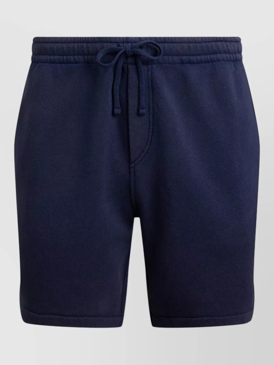 Polo Ralph Lauren Cotton blend sweatshorts — The off-white tailored chino short keeps the preppy, minimalist mood and pairs tonally with the camel tee for a clean, quiet-luxury summer palette and slightly smarter polish than elastic-waist options.
